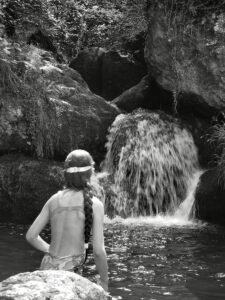 India sentada frente a una cascada