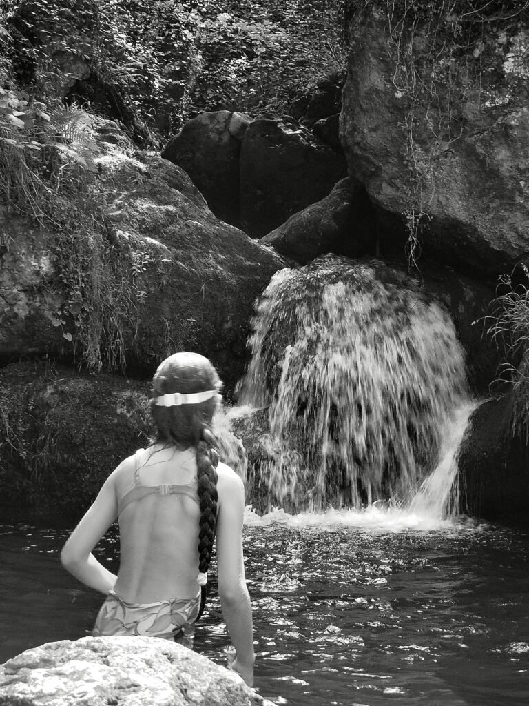 India sentada frente a una cascada